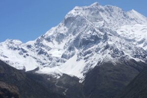 Mount Manaslu Above the Valley Near Samagaon Snow-covered face of Mount Manaslu rising above a glacier valley, with Samagaon village below
