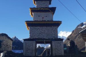 Kani Gate at the Entrance to Samdo Village, Manaslu Circuit Stone kani gate with painted Buddha eyes at the entrance to Samdo village, with snow peaks behind