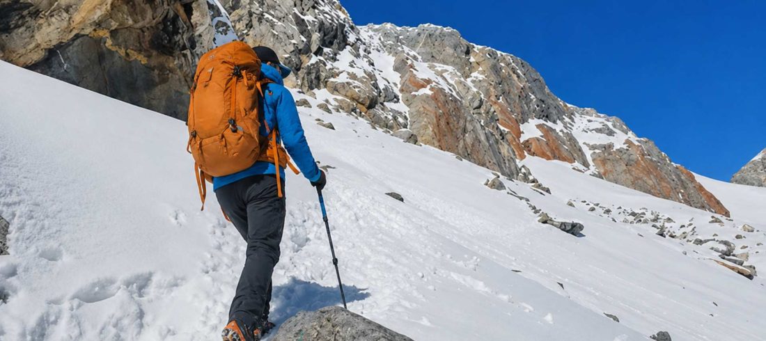 Trekker ascending a steep snowy slope during the challenging Everest Three Passes Trek in Nepal.