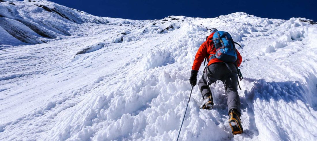 Climber ascending a steep snow and ice slope during the challenging Island Peak Climbing expedition in Nepal