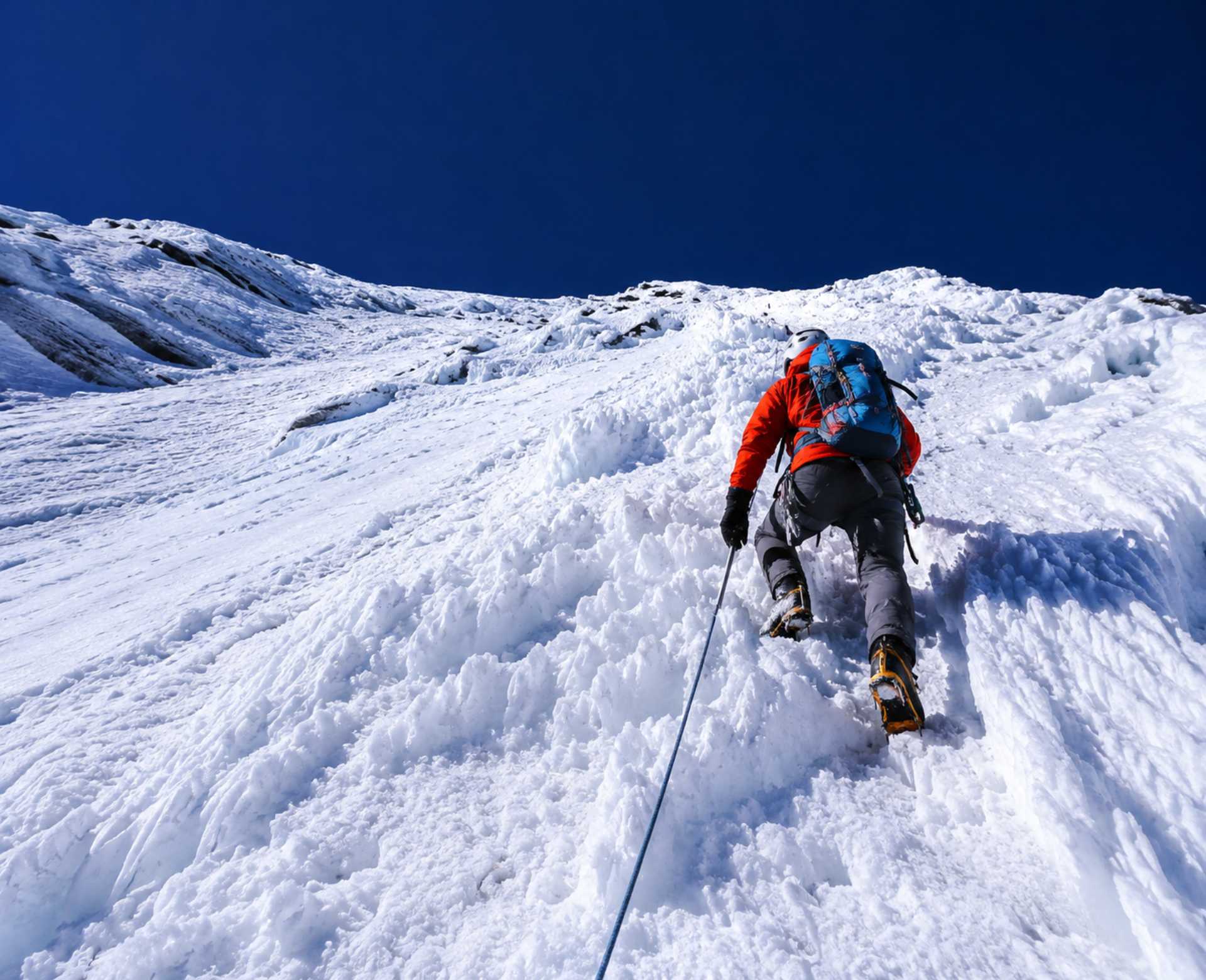 Climber ascending a steep snow and ice slope during the challenging Island Peak Climbing expedition in Nepal