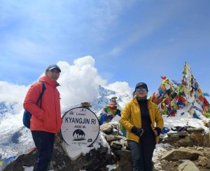 Kyanjin Ri Viewpoint During Yala Peak Trek in Langtang Trekkers at Lower Kyanjin Ri viewpoint in Langtang Valley with snow-covered Himalayan peaks and prayer flags during a Yala Peak trek.