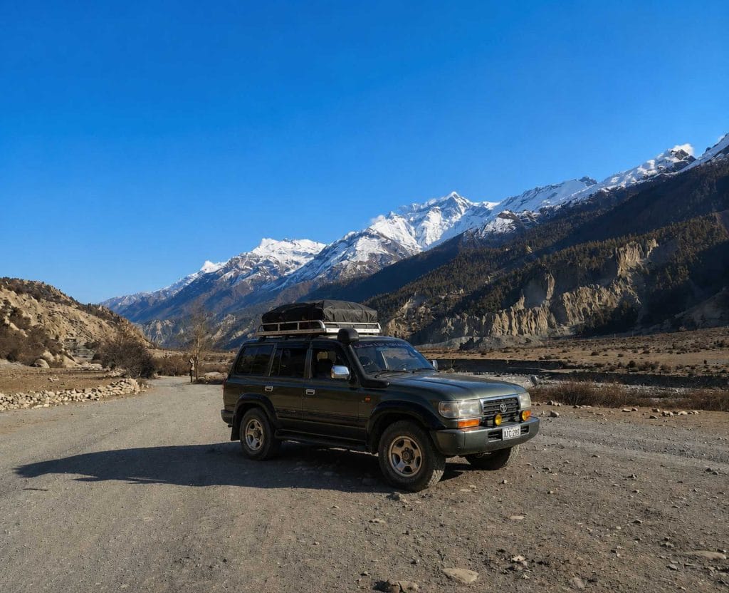 Manang Valley Jeep Tour with a black 4WD jeep on the scenic mountain road in the Annapurna region of Nepal