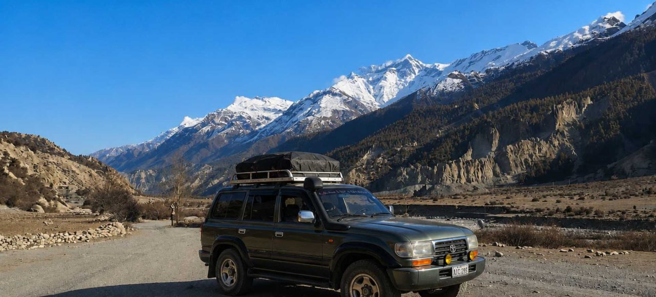 Manang Valley Jeep Tour with a black 4WD jeep on the scenic mountain road in the Annapurna region of Nepal