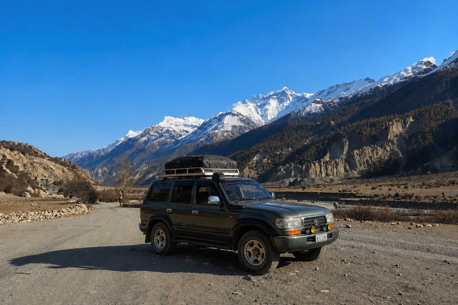 Manang Valley Jeep Tour with a black 4WD jeep on the scenic mountain road in the Annapurna region of Nepal
