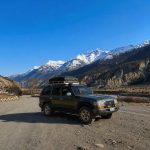 Manang Valley Jeep Tour with a black 4WD jeep on the scenic mountain road in the Annapurna region of Nepal