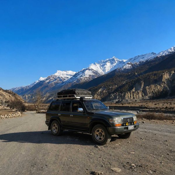Manang Valley Jeep Tour with a black 4WD jeep on the scenic mountain road in the Annapurna region of Nepal