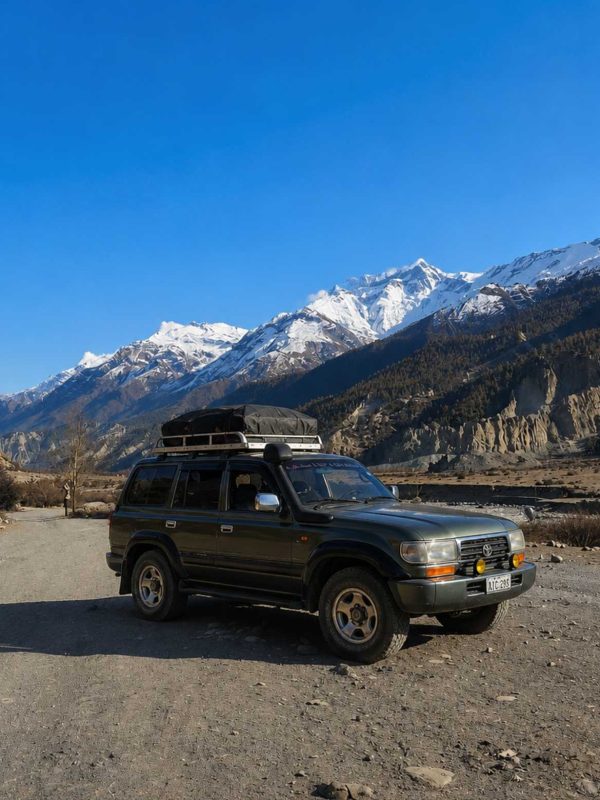 Manang Valley Jeep Tour with a black 4WD jeep on the scenic mountain road in the Annapurna region of Nepal