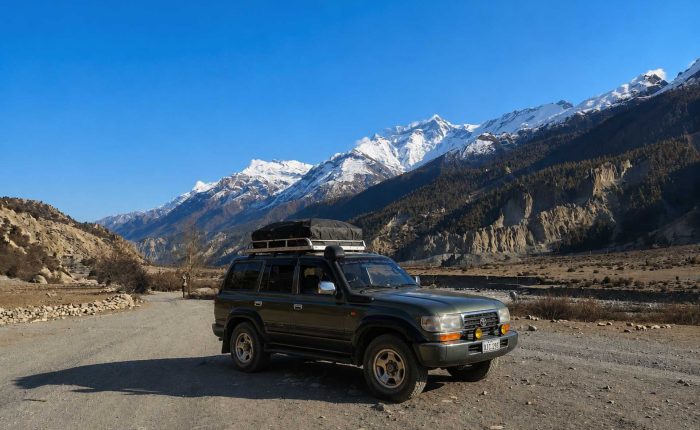 Manang Valley Jeep Tour with a black 4WD jeep on the scenic mountain road in the Annapurna region of Nepal