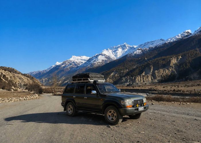 Manang Valley Jeep Tour with a black 4WD jeep on the scenic mountain road in the Annapurna region of Nepal