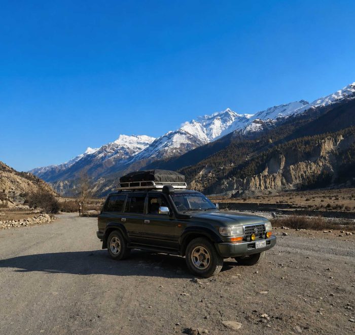 Manang Valley Jeep Tour with a black 4WD jeep on the scenic mountain road in the Annapurna region of Nepal