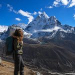 Solo trekker enjoying panoramic Himalayan views during the Nangkartshang Peak Trek in Nepal.