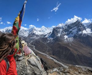 Woman enjoying the breathtaking mountain panorama during the Nangkartshang Peak Trek in Nepal's Everest region.