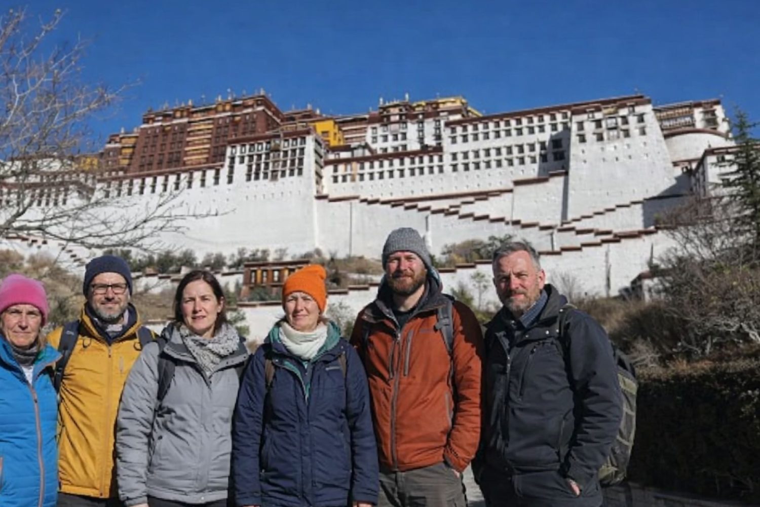 Group of trekkers standing in front of the Potala Palace during the Tibet Overland Tour from Nepal