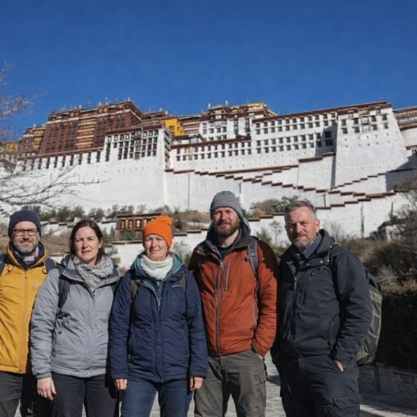 Group of trekkers standing in front of the Potala Palace during the Tibet Overland Tour from Nepal