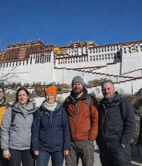 Group of trekkers standing in front of the Potala Palace during the Tibet Overland Tour from Nepal
