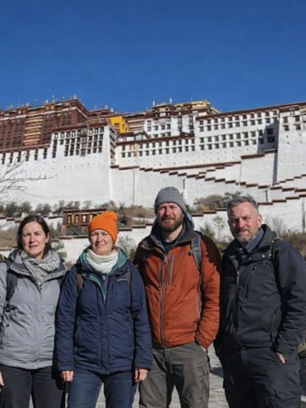 Group of trekkers standing in front of the Potala Palace during the Tibet Overland Tour from Nepal