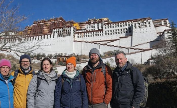 Group of trekkers standing in front of the Potala Palace during the Tibet Overland Tour from Nepal