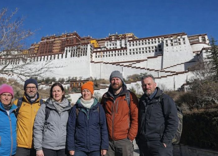Group of trekkers standing in front of the Potala Palace during the Tibet Overland Tour from Nepal