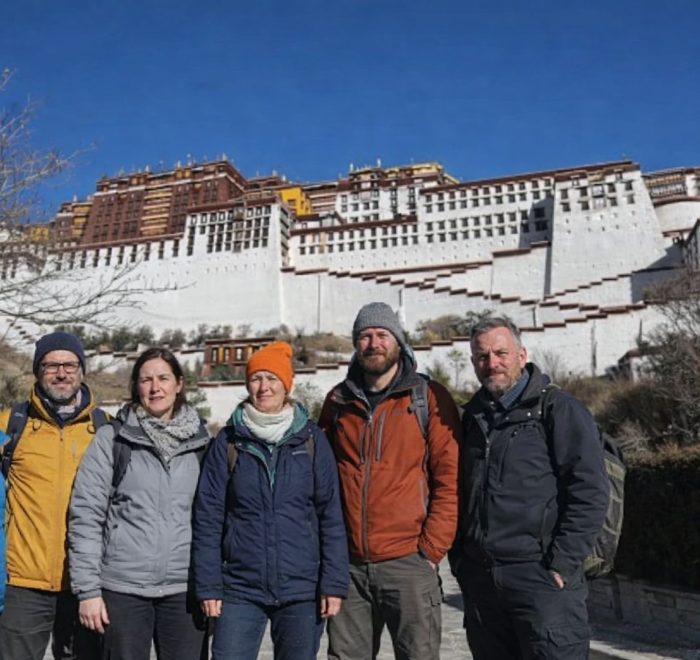 Group of trekkers standing in front of the Potala Palace during the Tibet Overland Tour from Nepal