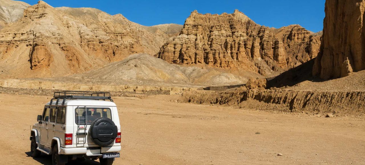 4WD jeep exploring the dramatic desert landscape on the Upper Mustang Overland Tour in Nepal