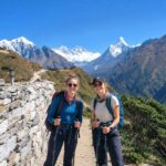 Two trekkers walking on the Everest View Trek trail with Himalayan mountain views