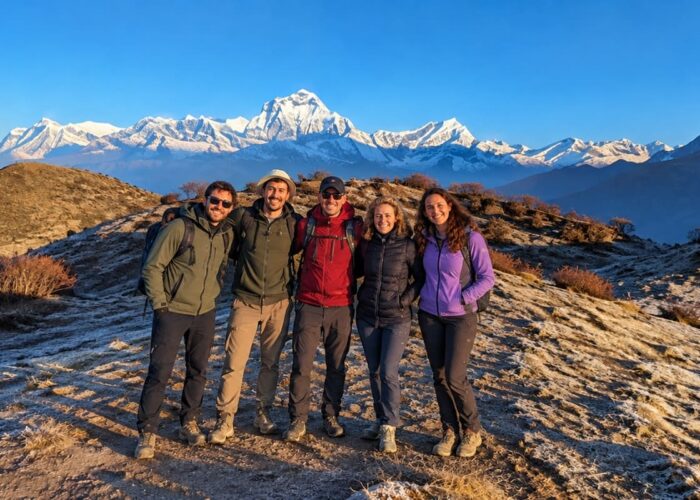 Trekkers smiling together with Mount Dhaulagiri and the Annapurna foothills in the background on the Dhaulagiri Annapurna Community Trek.