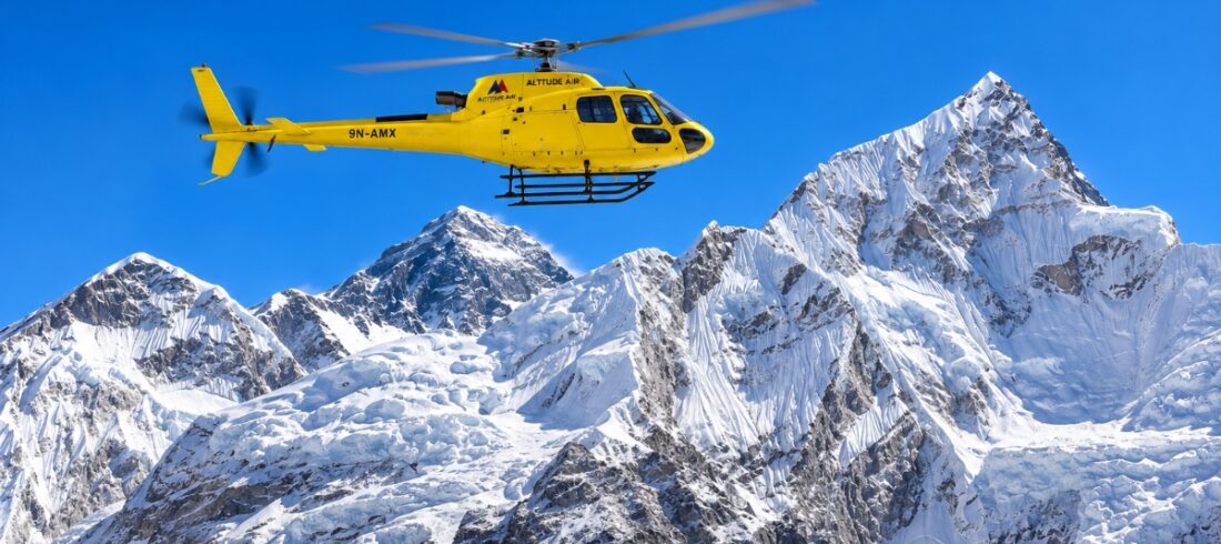 Yellow helicopter flying over the Himalayas during an Everest Base Camp helicopter tour in Nepal