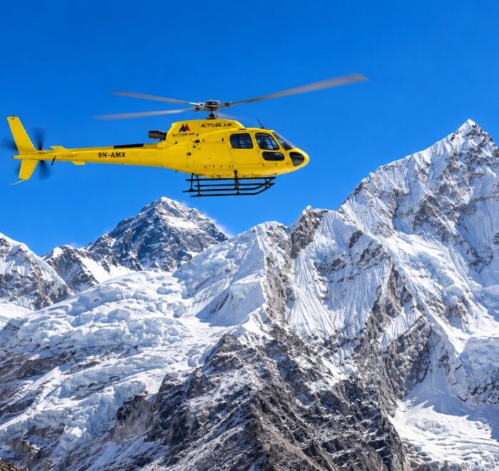 Yellow helicopter flying over the Himalayas during an Everest Base Camp helicopter tour in Nepal