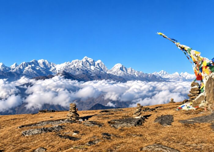 Pikey Peak Trek viewpoint with Himalayan mountains, prayer flags and stone cairns