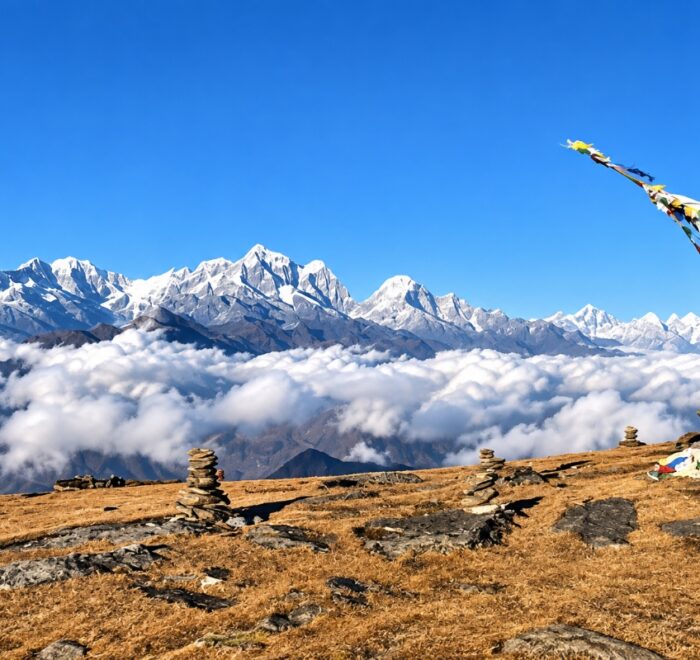 Pikey Peak Trek viewpoint with Himalayan mountains, prayer flags and stone cairns