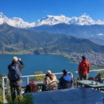 Tourists enjoying a view of Phewa Lake and the Annapurna range from Pokhara, Nepal