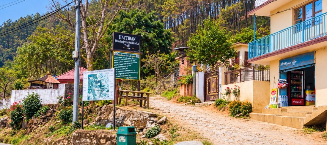 Hattiban trail sign and map board beside a cobbled path leading into pine forest, the start of the Champadevi hike