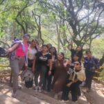 Group of hikers posing on forest stone steps with yellow railings on the trail from Sundarijal to Chisapani