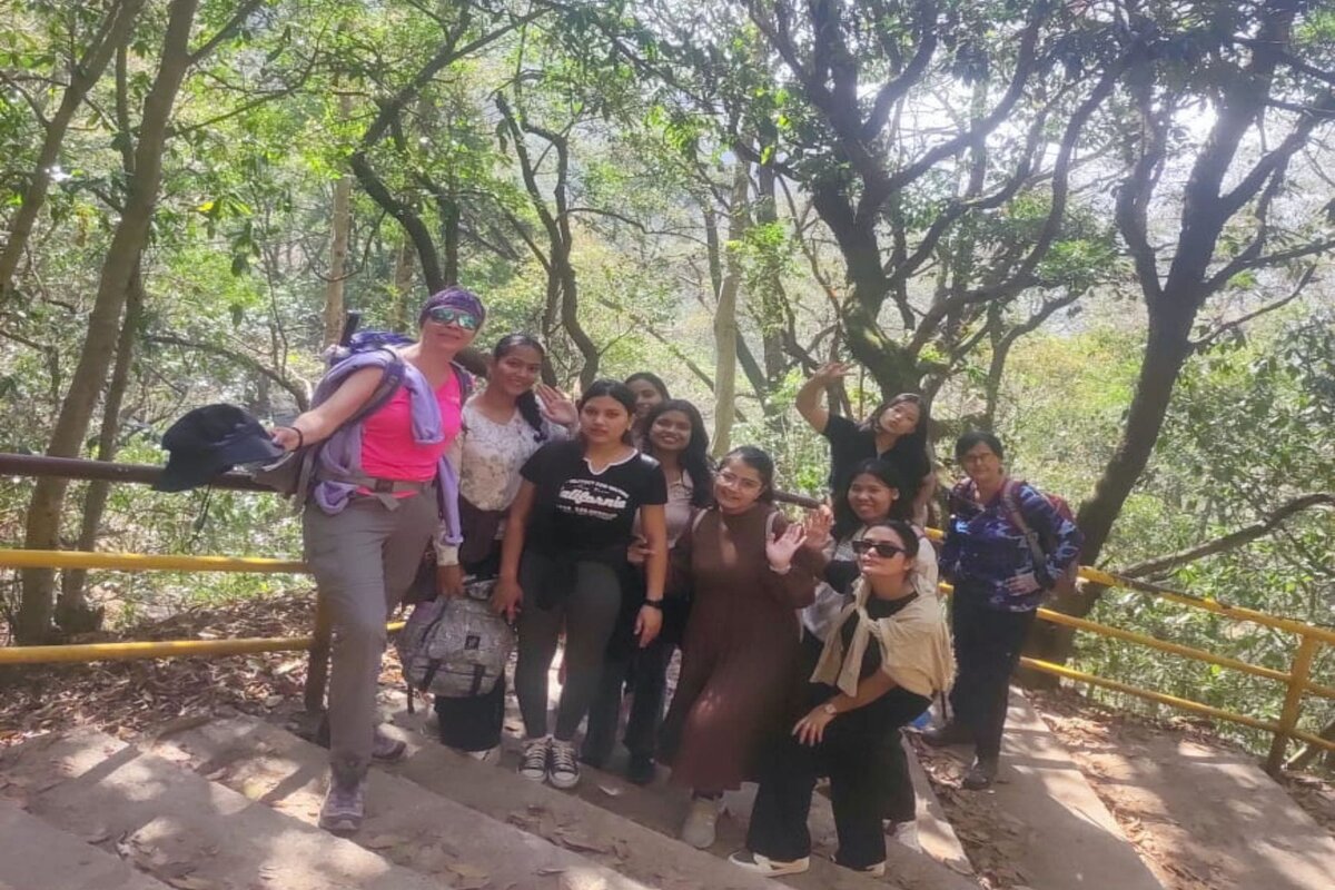 Group of hikers posing on forest stone steps with yellow railings on the trail from Sundarijal to Chisapani