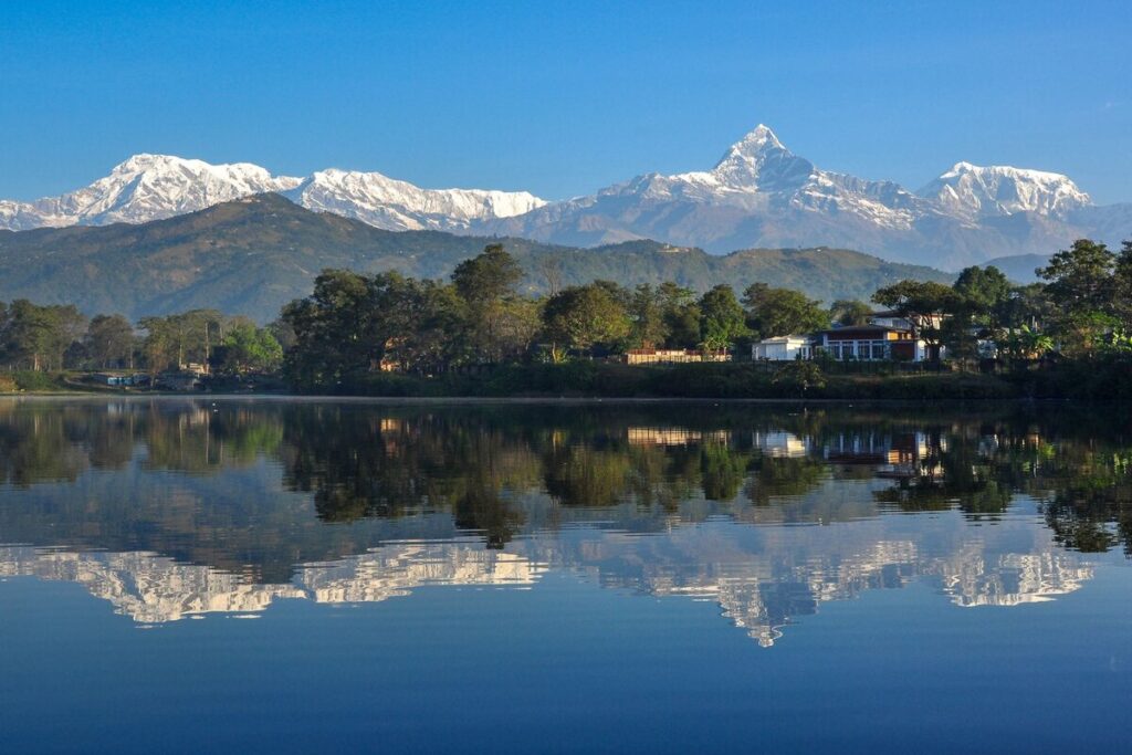 Machhapuchhre and the Annapurna range reflected in Phewa Lake, Pokhara, on a clear morning