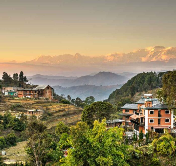 Bandipur village on its ridge at sunrise, with terraced fields below and the Himalaya behind
